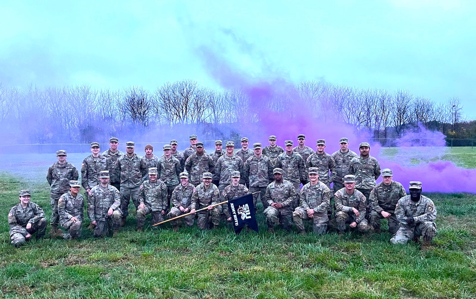 SIU Army ROTC cadets pose as a group behind purple smoke