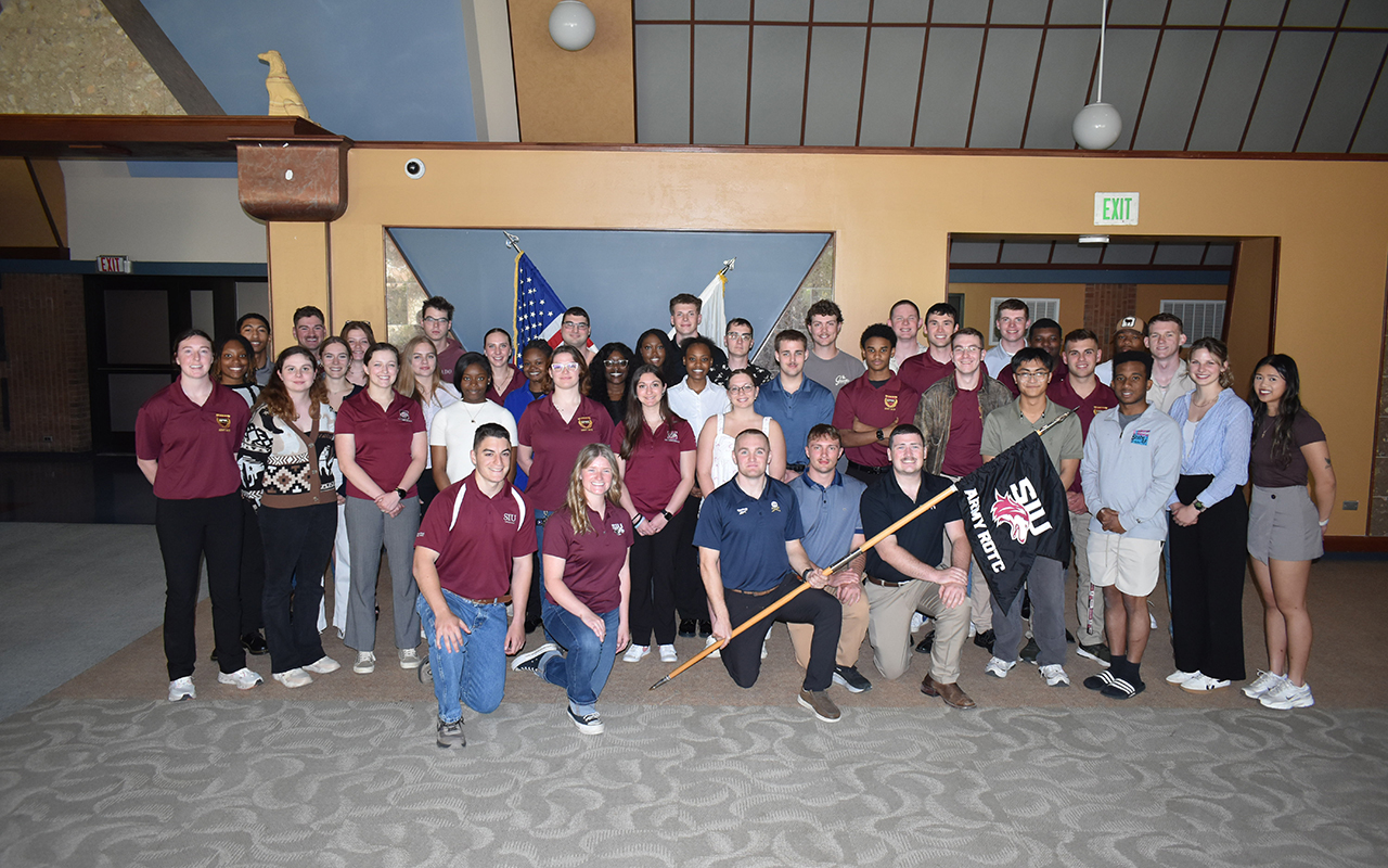 Award ceremony participants pose together with an SIU ROTC flag
